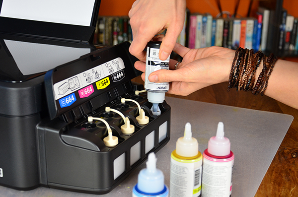 Inkttankprinter die gevuld wordt met een inktflesje